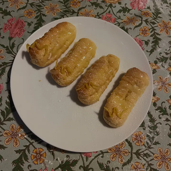 Four lemon curd eclairs on a white plate