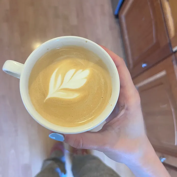 Holding a flat white with tulip latte art